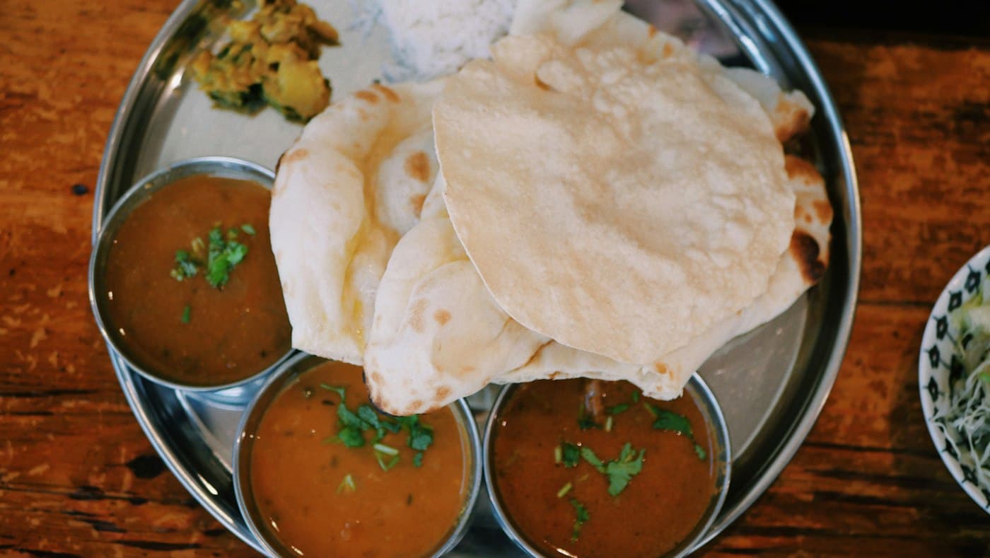 Fresh naan with bowls of dal
