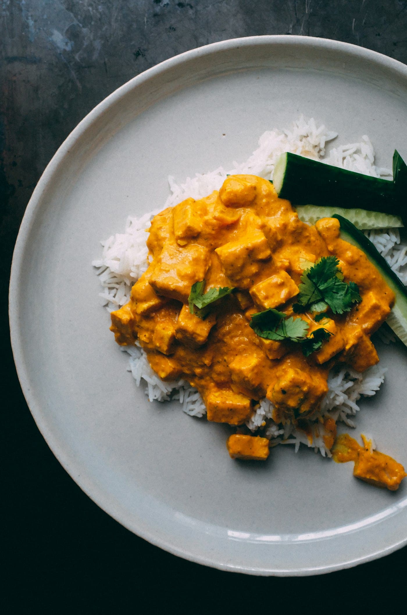 Paneer curry with rice on a grey plate